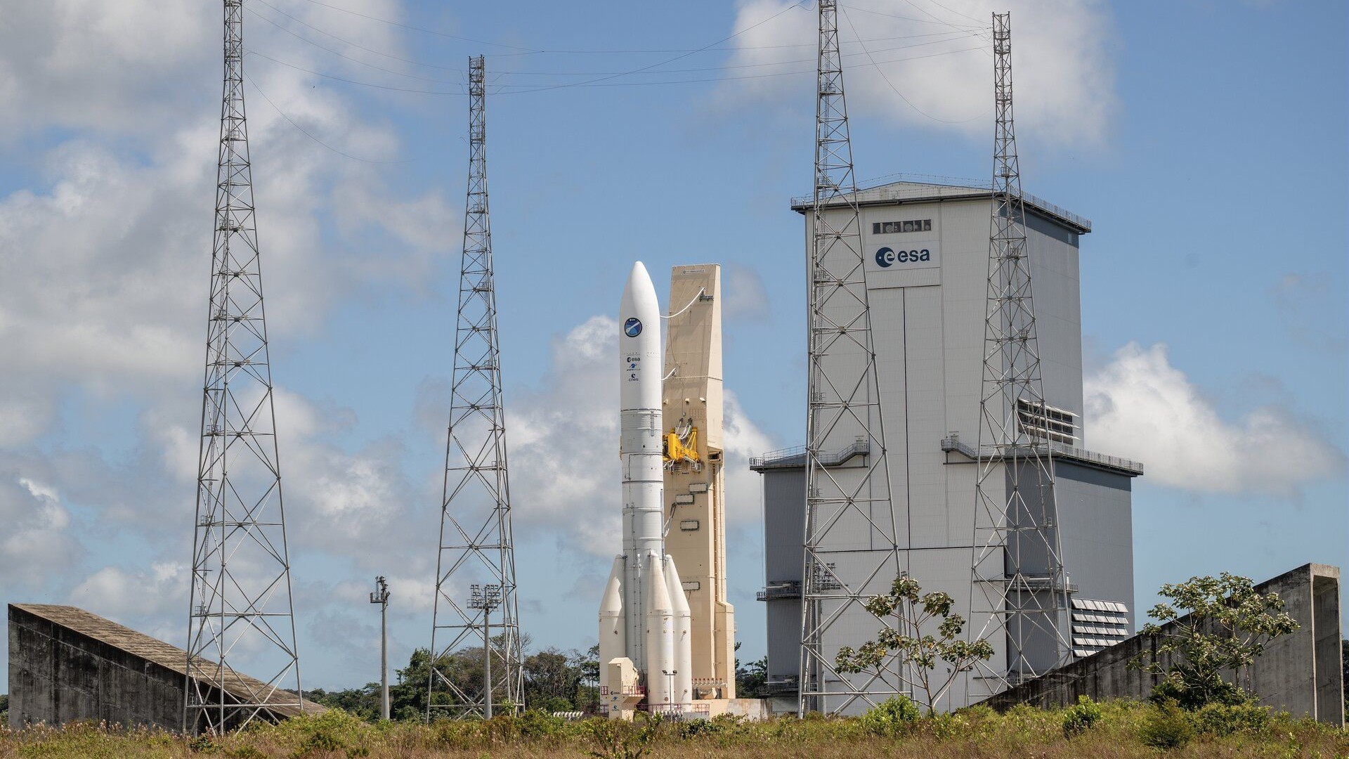 矗立在发射塔架旁的 Ariane 6 火箭与 ESA 航天中心建筑